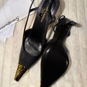 Saint Laurent Jeanne embellished glossed-leather slingback pumps.